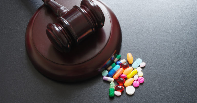 pharmaceutical pills next to a gavel | Kendall PC